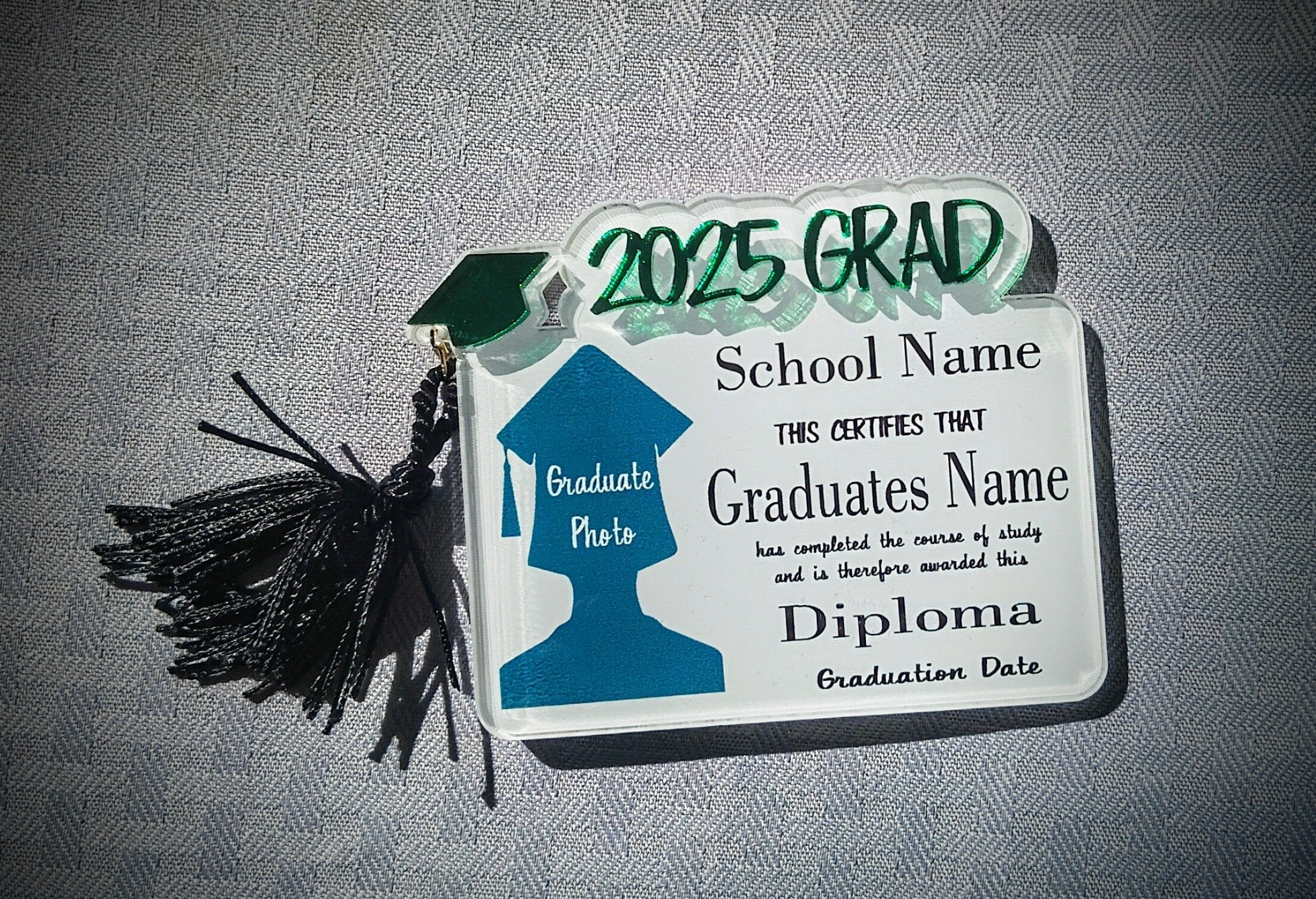Graduation-themed decorative item with tassel on a gray background